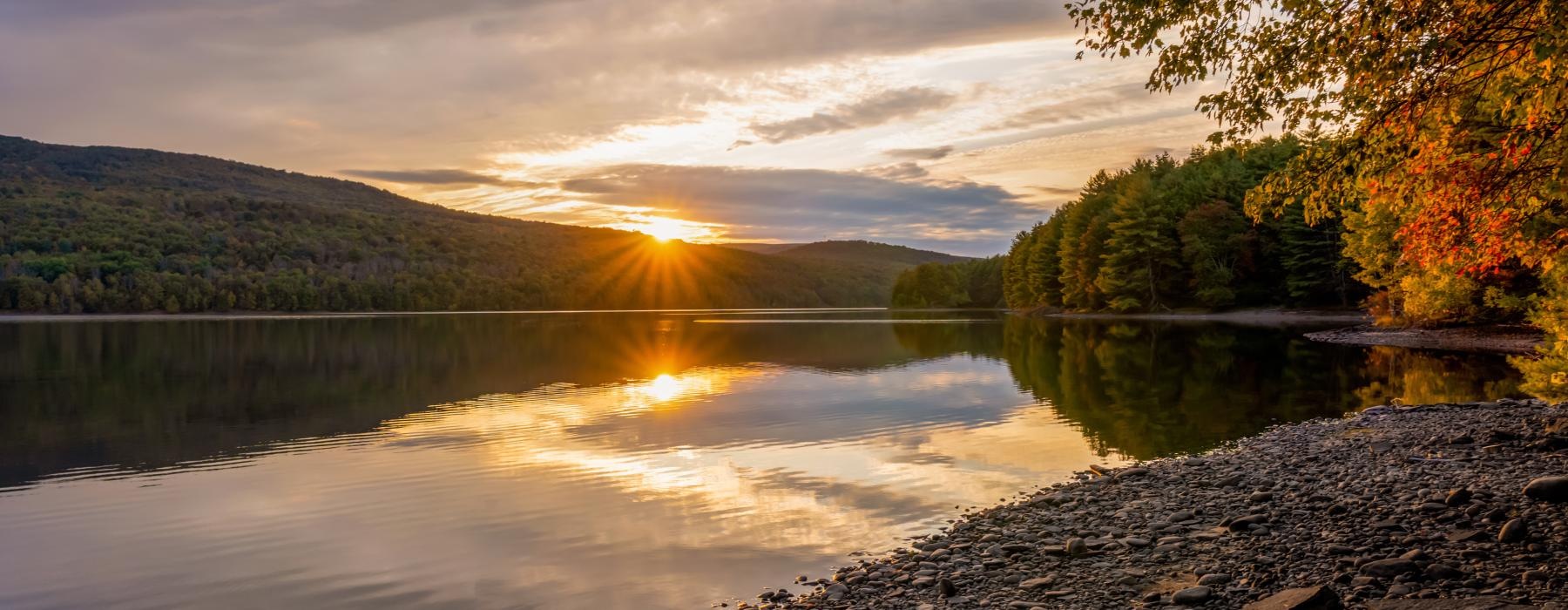 a lake with trees and hills around it