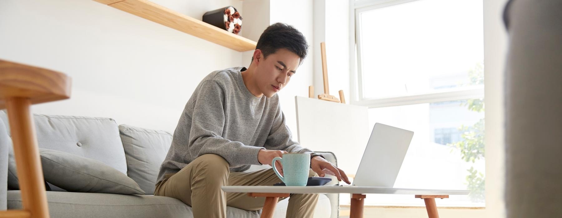 a man sitting on a couch using a laptop